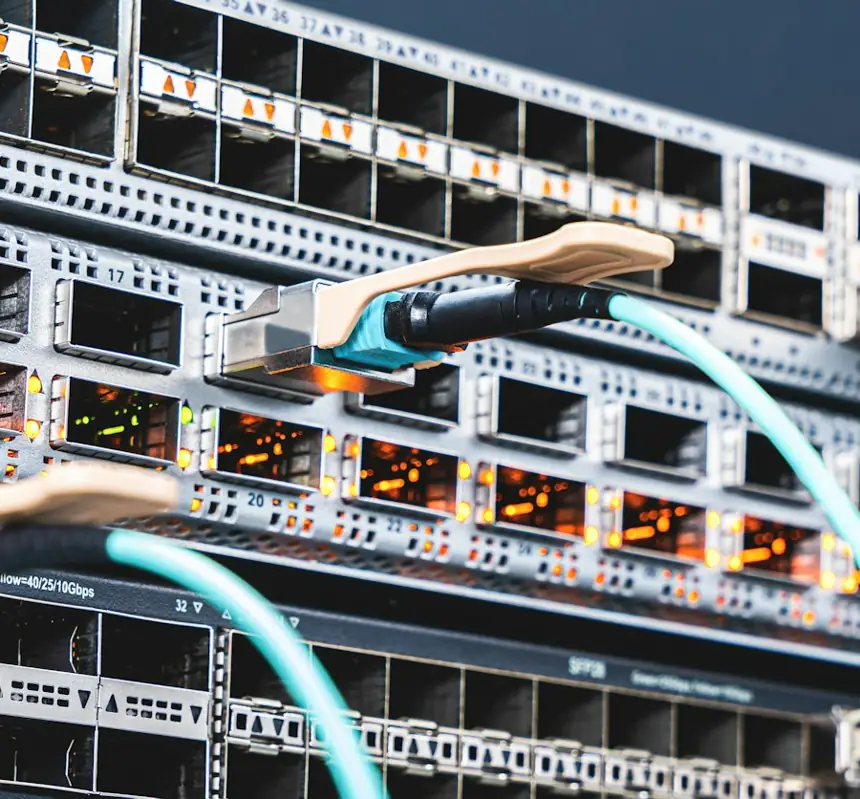 Cabos de fibra óptica conectados a switch corporativo, infraestrutura de link dedicado e internet corporativa da One Corp no RS