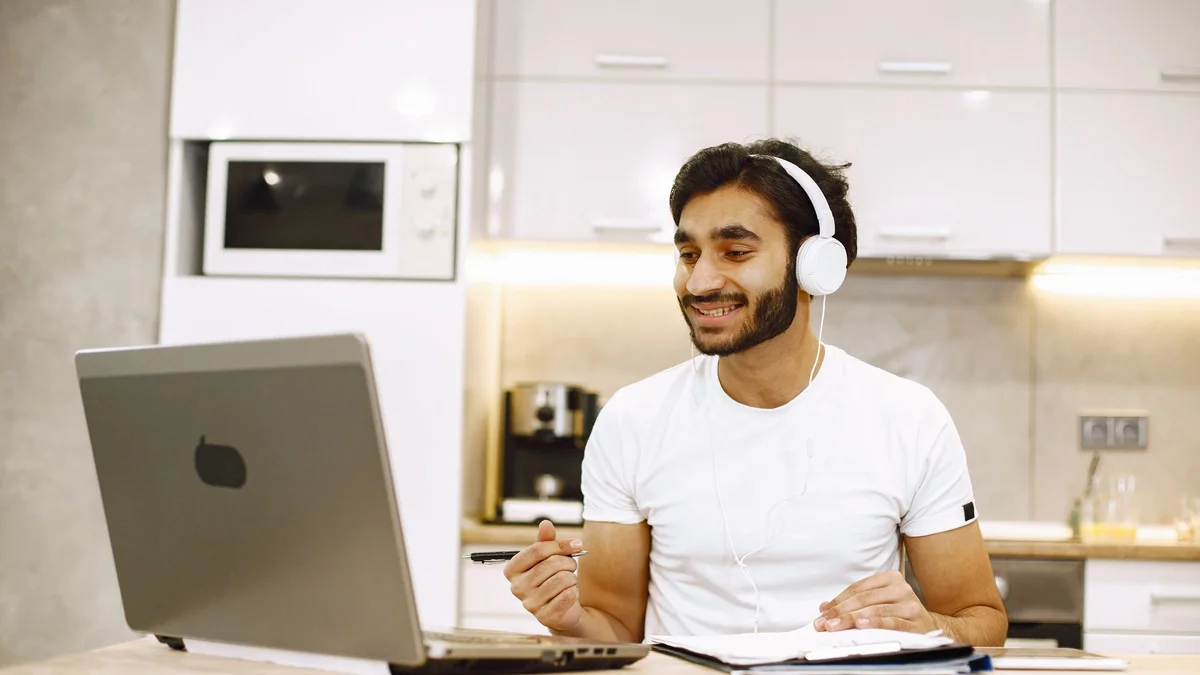 Profissional atendendo de casa pelo notebook, com fone de ouvido, usando o ramal da empresa no PABX na nuvem
