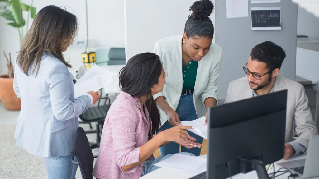 Equipe trabalhando no escritório com computadores e operação funcionando normalmente