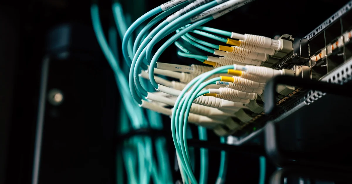 Cabos de fibra óptica conectados a um equipamento de rede, a base de um link dedicado para empresas