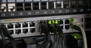 Equipamento de rede com cabos conectados e luzes de atividade acesas, base de uma internet com redundância