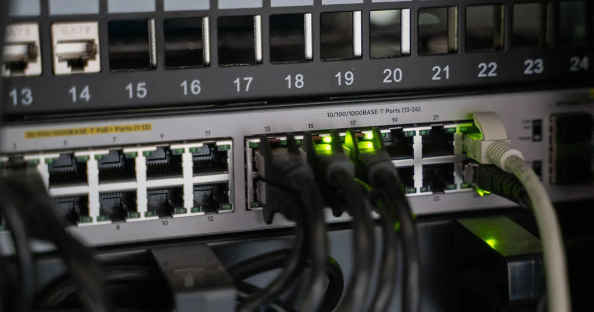 Equipamento de rede com cabos conectados e luzes de atividade acesas, base de uma internet com redundância