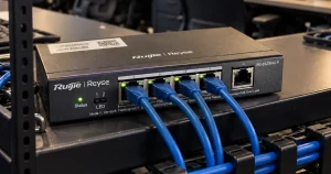 Switch PoE com cabos de rede azuis conectados, instalado no rack de um escritório
